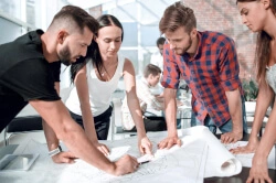 Grupa architektów i stolarzy dyskutujący nad projektem